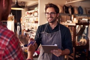 A salesuses a tablet to complete a transaction