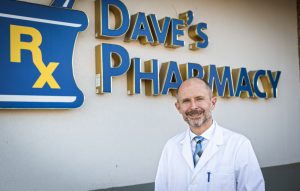 David Burke, a pharmacist, stands in front of his pharmacy.