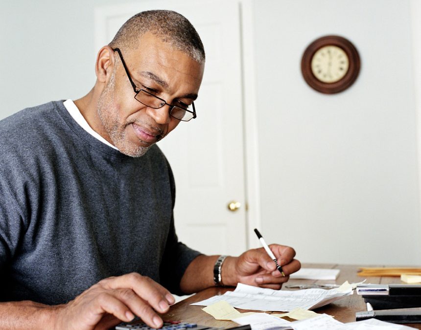 Mature man doing finances in home office